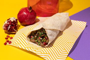 beef shawarma sandwich on bright background. Burritos wraps with grilled chicken. Fajitas, pita bread. Traditional Middle Eastern appetizer. Colorful food photography, bright color food image.