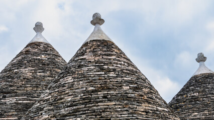 Traditional trulli houses.  Conical roofs made of stone slabs. Alberobello, province of Bari, Puglia region, Italy