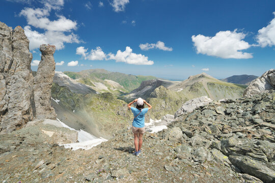Young girl in mountain travel. Mountains peaks and hills at summer day.