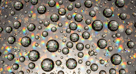Obraz premium Stunning water droplets create abstract reflections and vibrant rainbow light for a modern, fresh background or captivating science visual