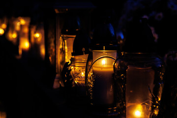 Nastrojowe ujęcie cmentarza po zmroku, gdzie jedynym źródłem światła są palące się znicze. Migoczące płomienie tworzą ciepłą, melancholijną atmosferę, podkreślając duchowy i refleksyjny wymiar miejsca © Michał.S-FOTO