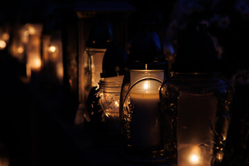 Nastrojowe ujęcie cmentarza po zmroku, gdzie jedynym źródłem światła są palące się znicze. Migoczące płomienie tworzą ciepłą, melancholijną atmosferę, podkreślając duchowy i refleksyjny wymiar miejsca © Michał.S-FOTO