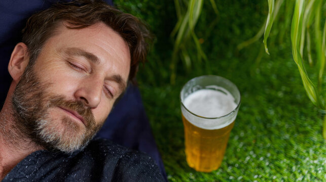 A serene Caucasian man naps beside a frothy beer on lush grass, invoking Oktoberfest dreams and relaxation rituals - Powered by Adobe