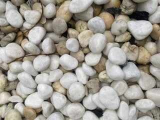 Smooth gray and white pebbles on a beach create a natural, textured pattern for an abstract background