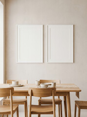 Two blank white vertical poster frames mockup set on light wall in Japandi dining room interior wooden table chairs minimalism front view flat lighting high resolution double canvas design 