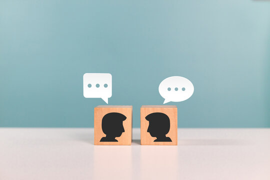 Wooden cube with people icons and speech bubbles represents communication connections. Social media, interaction and chat