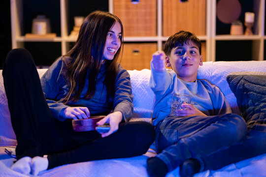 Siblings enjoying relaxed movie night at home