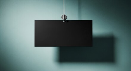 Modern black flat screen television mounted on a light blue wall with shadow