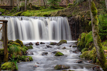 Fototapeta premium A long exposure view of a waterfall in a small rapid river, autumn landscape, November in nature, Ieriku mill, Melderupe, Latvia