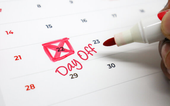 Vivid red marker highlights an upcoming day off on a monthly calendar, symbolizing planned leisure and scheduled breaks from work