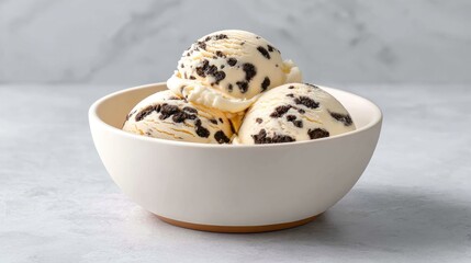Creamy vanilla ice cream with cookie chunks served in a modern bowl on a light textured surface, ideal for dessert lovers and food enthusiasts