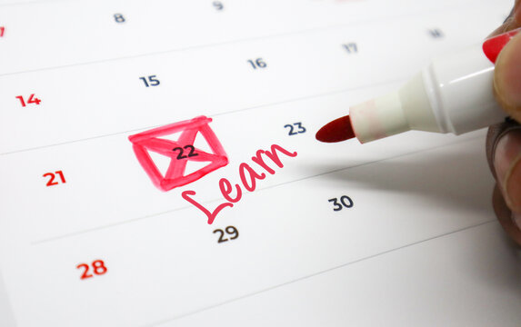 Circling an important Learn event on a calendar with a red marker, signifying a scheduled milestone for personal development and educational pursuits