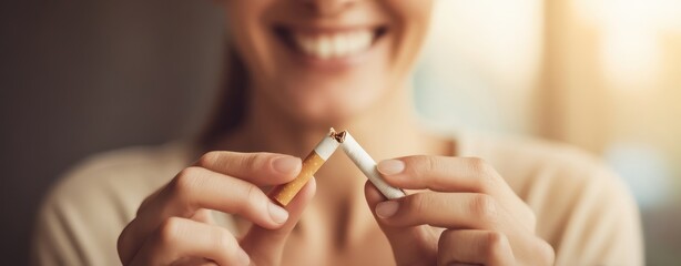 The cigarette being broken by a smiling woman as she quits smoking today