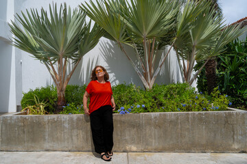 La mujer de la tercera edad está sentada tomando el sol.