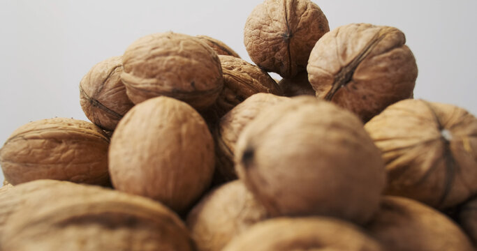 Unshelled fresh walnuts with hard textured shells in a heap, side view. Pile of nuts