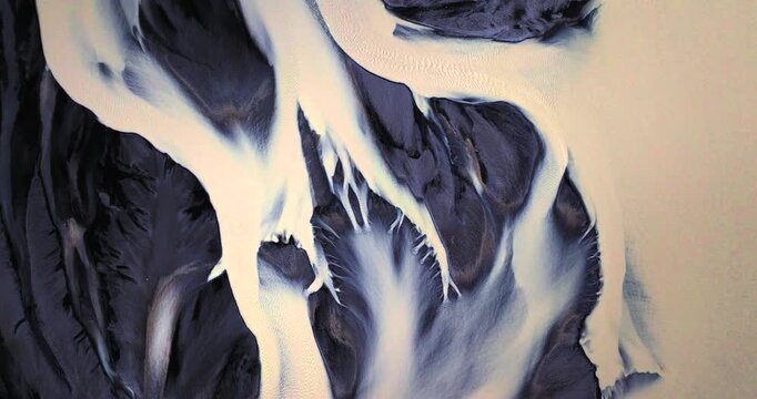 This cinematic drone clip showcases the surreal textures of Skei&eth;ar&aacute;rsandur, where icy glacial waters paint luminous streaks over black sands, creating a breathtaking natural masterpiece from above.