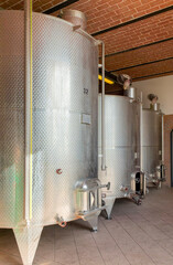 row of wine storage tanks in a farm winery in tuscany italy