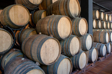wine barrels stacked in a warehouse at a winery at san gimignano tuscany italy