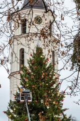 Workers decoration the Christmas tree with baubles in Cathedral square in Vilnius, Lithuania
