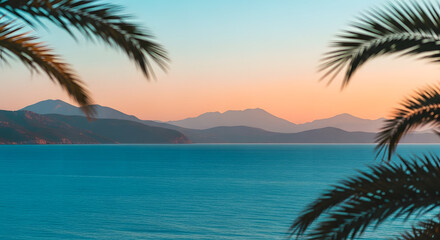Tropical sea view with palm trees at sunset over distant mountains