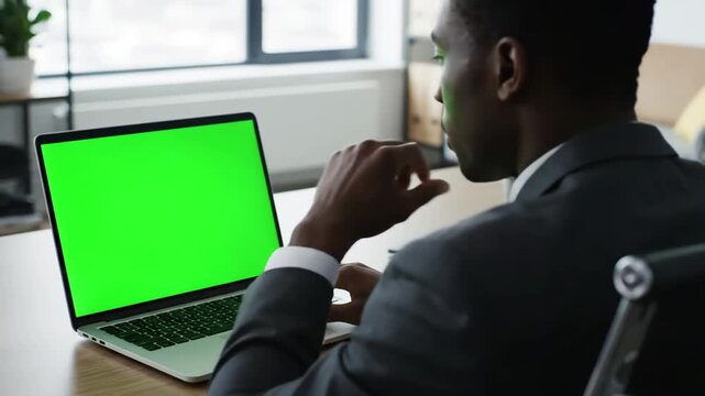 Green Screen successful black businessman sitting at desk working on laptop computer in office anonymous businessperson using chroma key display stylish bright workplace over shoulder close up scene 4