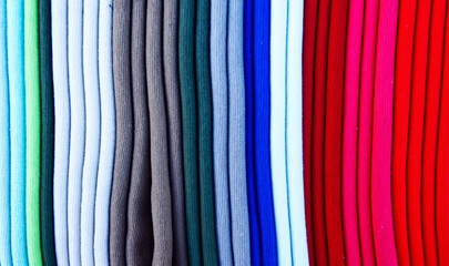 Vibrant retail display showing colorful rolls of cotton fabric in a spectrum, textile threads...