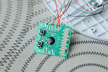 Disassembled electronic device kitchen scales with circuit board wires plastic parts on a table.Useful for articles about electronics repair, DIY projects, device maintenance and engineering tutorials