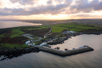 Aerial view of Port Oriel in Clogherhead with fishing boats and hazy evening light along the calm coastline