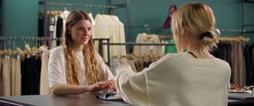 Woman paying at checkout counter in clothing store