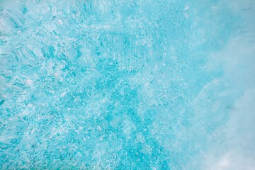 A close-up, abstract background of blue water. The texture is dynamic, with various shades of bright aqua, suggesting cold.The natural pattern fresh, pure, and cool backdrop for water-themed designs.
