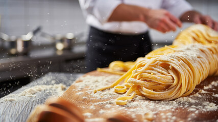 Chef preparing fresh pasta with flour in kitchen