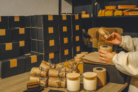 Artisan candles being packaged for sale in a small business workshop - Powered by Adobe