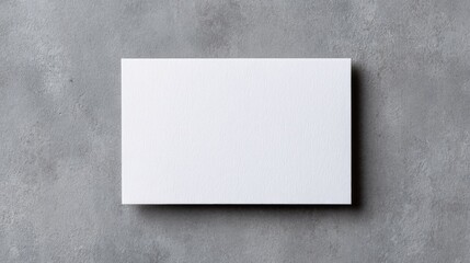 Small business branding mockup, A plain white card rests on a textured gray surface, creating a minimalist and modern aesthetic.
