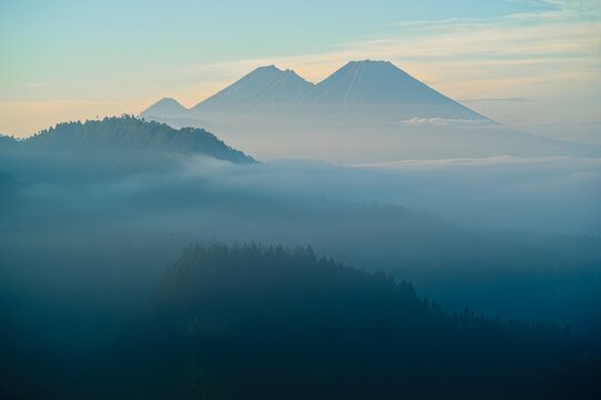 Misty Mountain Landscape with Volcanic Peaks at Dawn