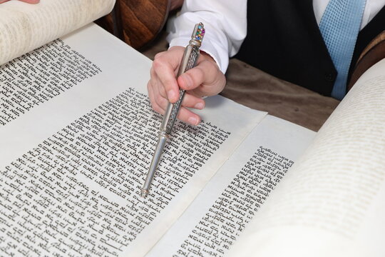 Hand of boy reading the Jewish Torah at Bar Mitzvah