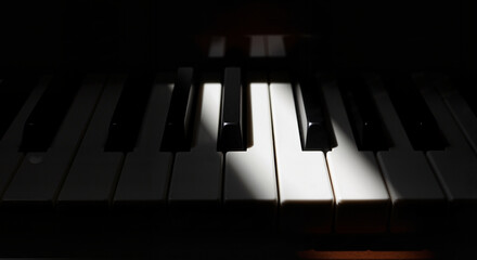 Piano keys in shadow with light contrast creating artistic effect 