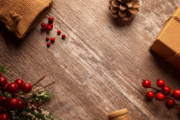 Rustic Christmas background with pinecone, berries and greenery on wooden surface, ideal for winter promotions, holiday templates, greeting cards and festive designs