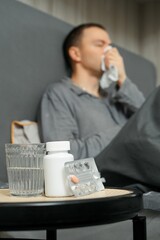 Cold medicine and water on bedside table