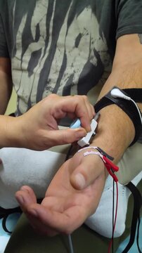Electromyography. A man undergoes an examination on an electromyograph. A new field in medicine is electroneuromyography - vertical video