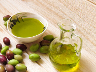 Greek olive oil. Natural, eco-friendly olive oil in Greece with a bottle and small dish, surrounded by fresh green and black olives on the table.