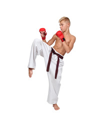 A bare-chested karate guy wearing red gloves prepares to kick.