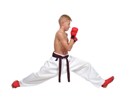 A karate boy in white pants and red gloves does the splits.