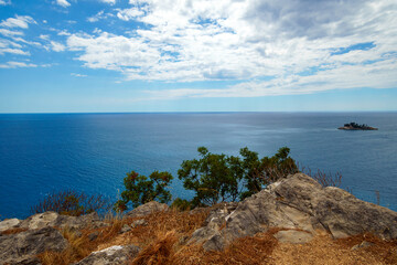 Fototapeta premium View from top of cliff to beautiful Adriatic seascape near Petrovac, Montenegro. Beautiful coast, rock, and island in sea