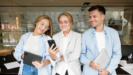 Team members collaborate while using digital devices