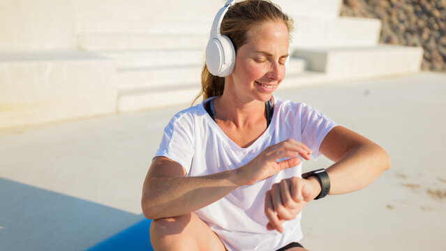 Woman checking smartwatch while exercising outdoors