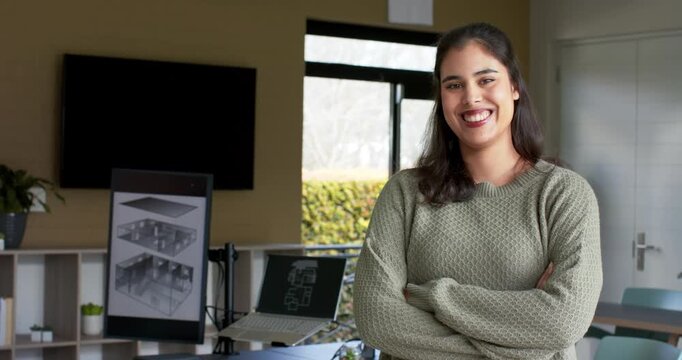 Woman softening neutral expression into confident smile showing confidence in office with screen