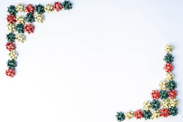 Red, green and gold tiny, gift bows framing two corners, on white background