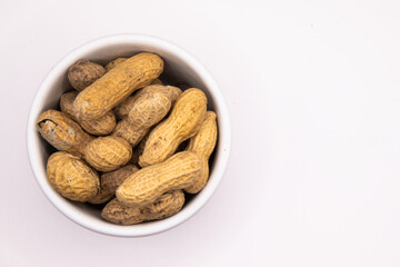 Monkey nuts in white dish on plain background