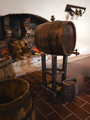 Traditional Wooden Barrel on a Stand in a Historic Basement or Inn with an Ancient Bonfire and Old Bricks in the Background, Rustic Style