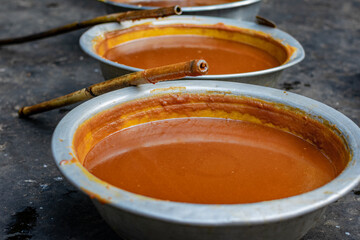 Vertical Row of Liquid Jaggery (Gur) Cooling in Metal Bowls